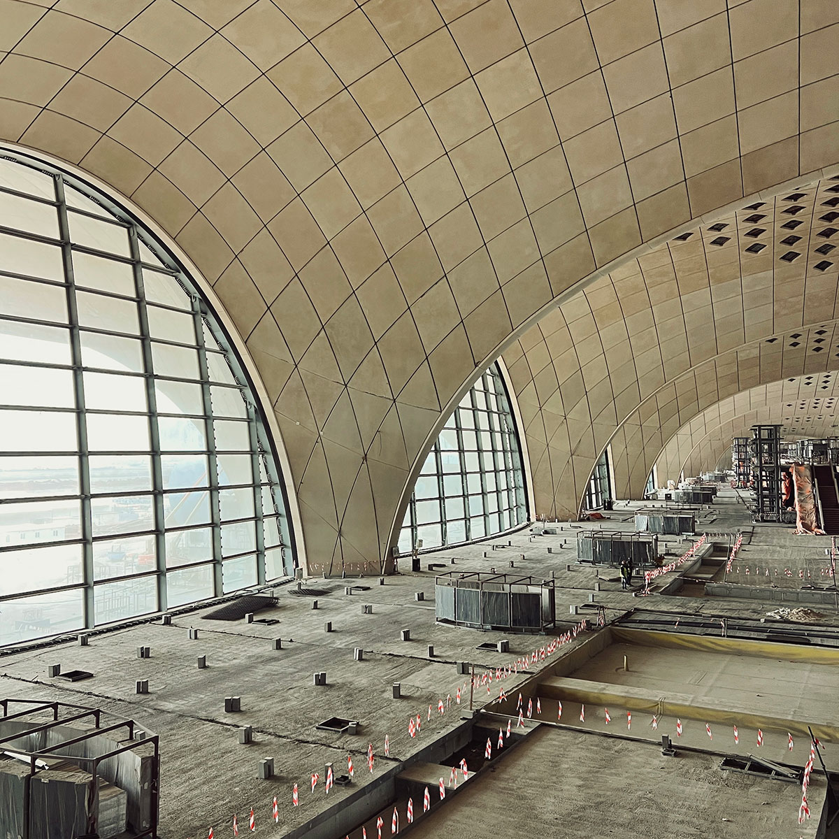 Kuwait International Airport T2 interior under construction — vaulted concrete arches and arched glazing